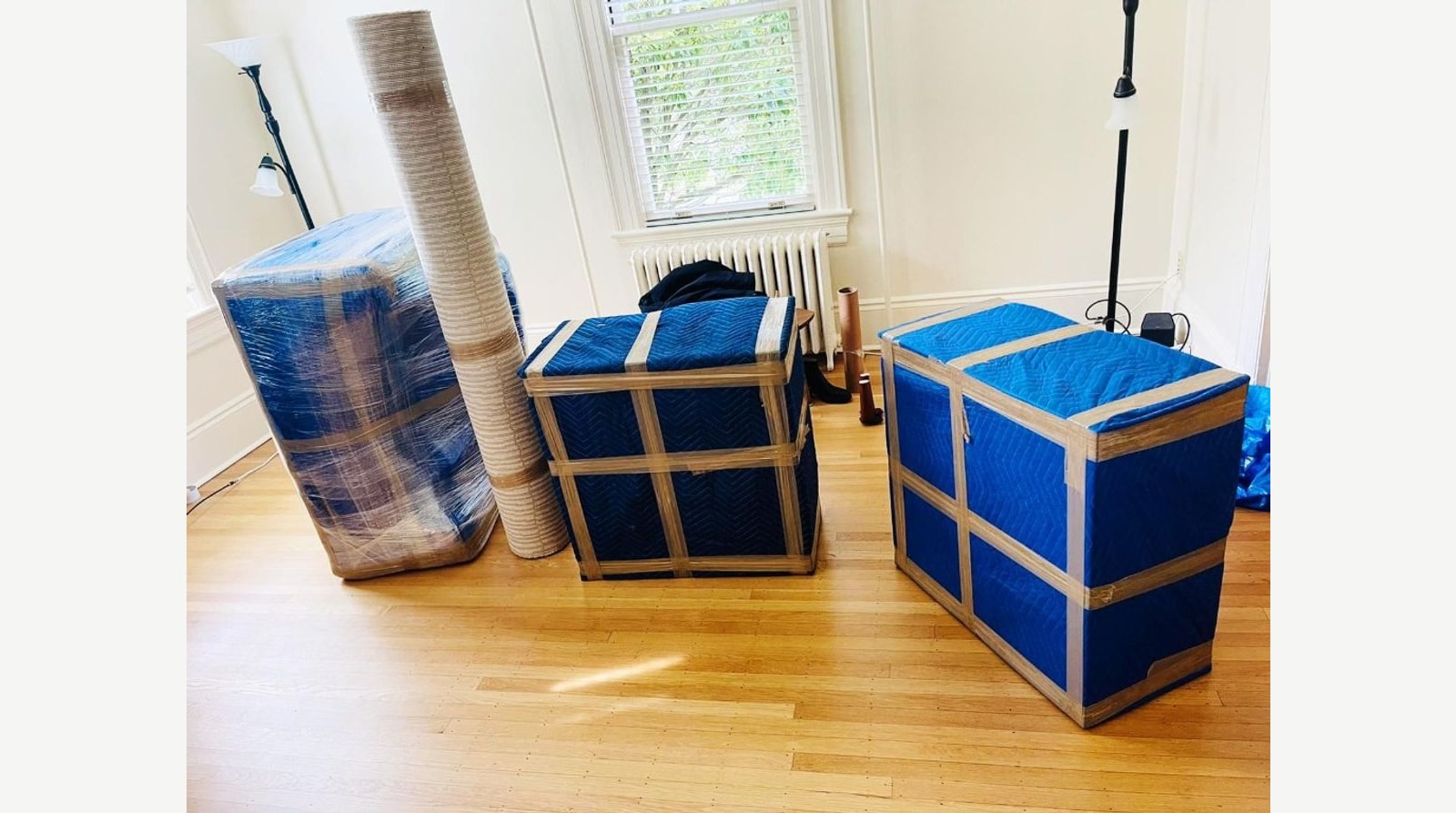 Furniture and rugs wrapped in quilted moving blankets and plastic film ready for a South Florida move