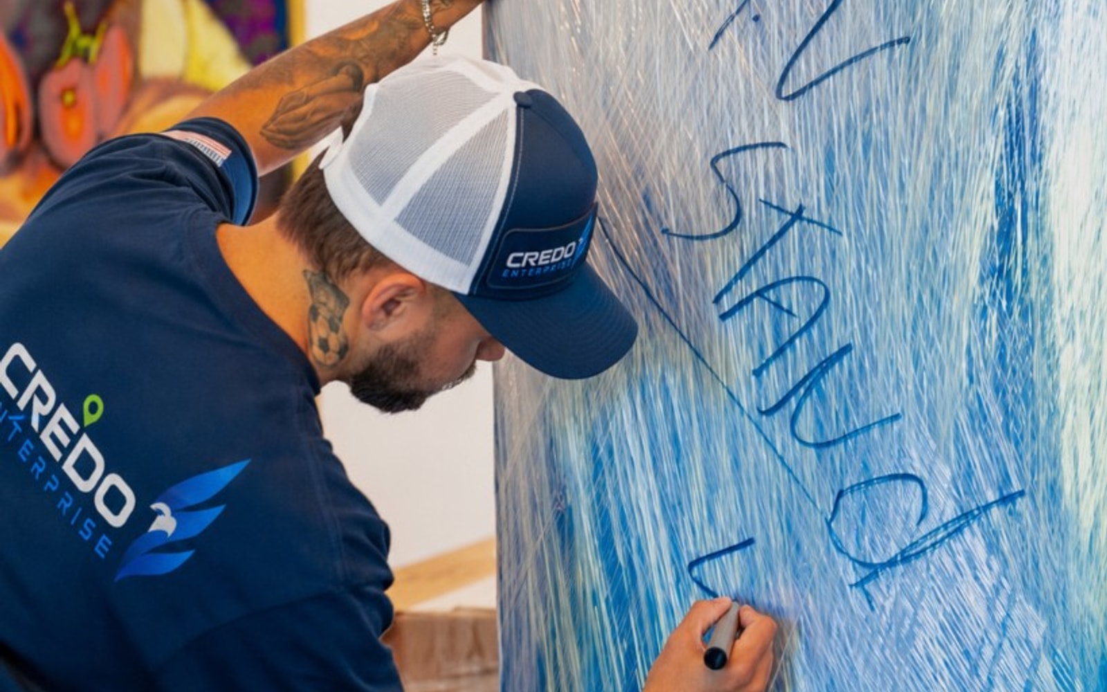 Credo Enterprise mover labeling a quilted furniture wrap with a marker during a careful move