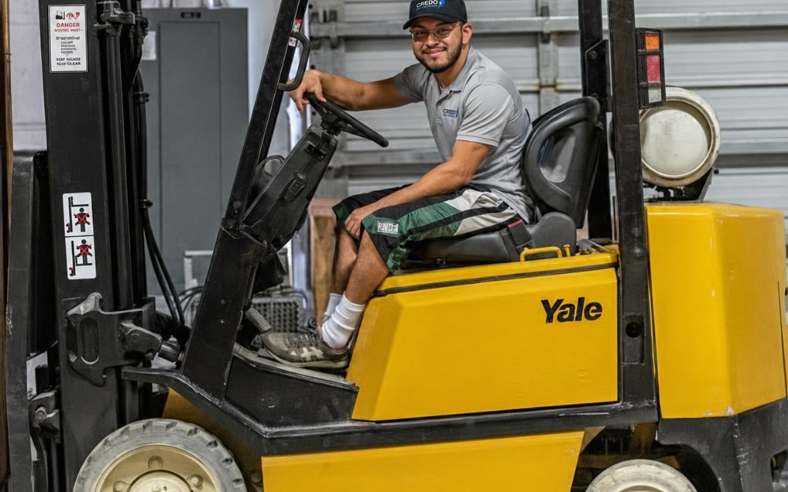 Credo Enterprise crew member operating a forklift at a warehouse storage facility